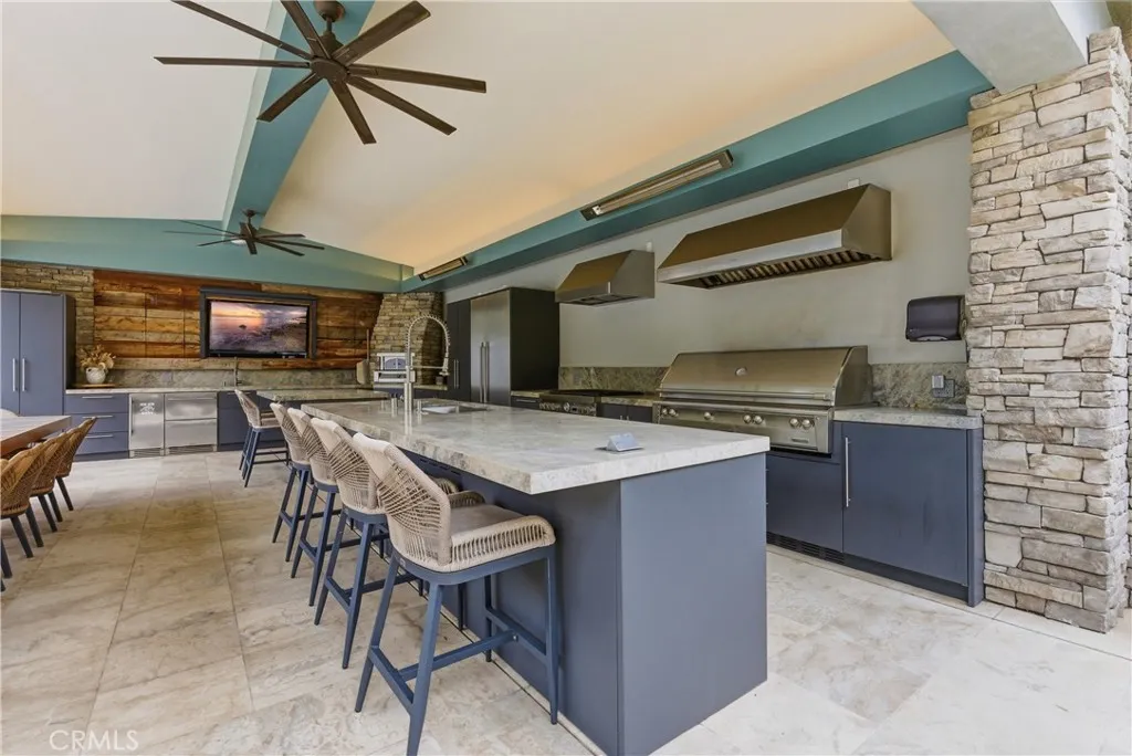 Outdoor kitchen with built-in BBQ, pizza oven and dining area