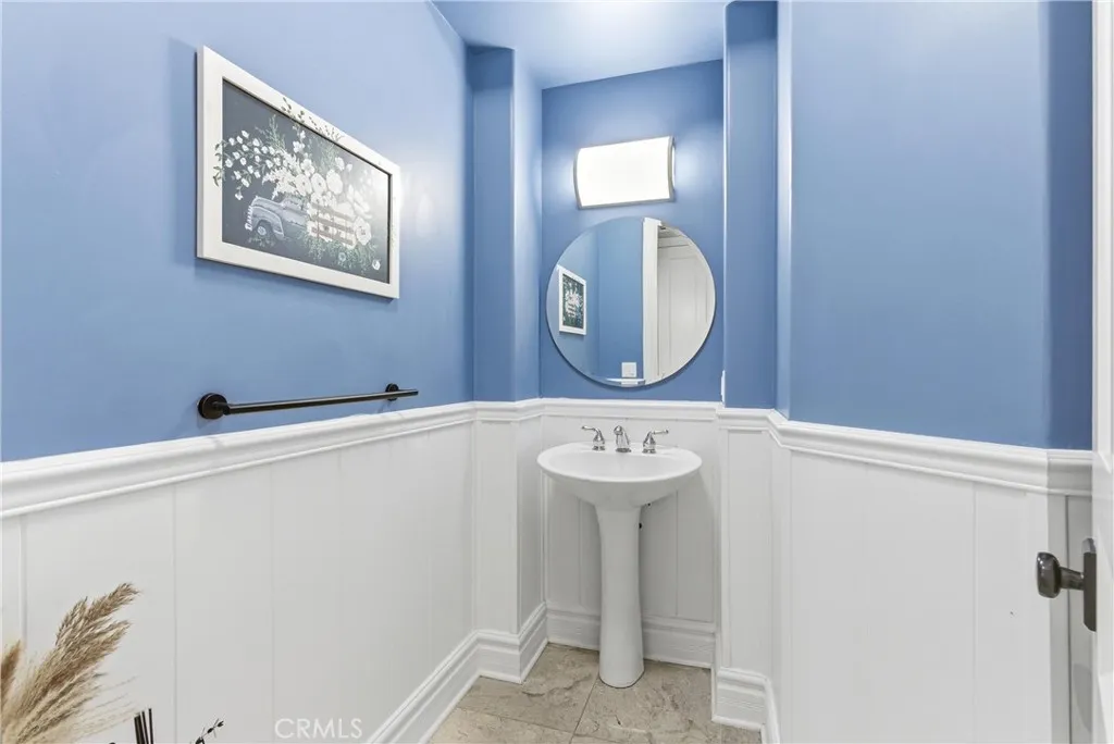 Powder room with pedestal sink and wainscoting