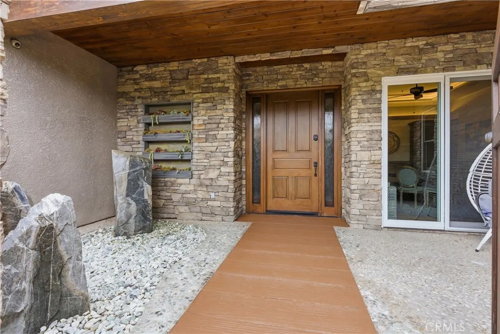 Front courtyard entry with waterfall feature, living plant wall, covered porch and wood front door