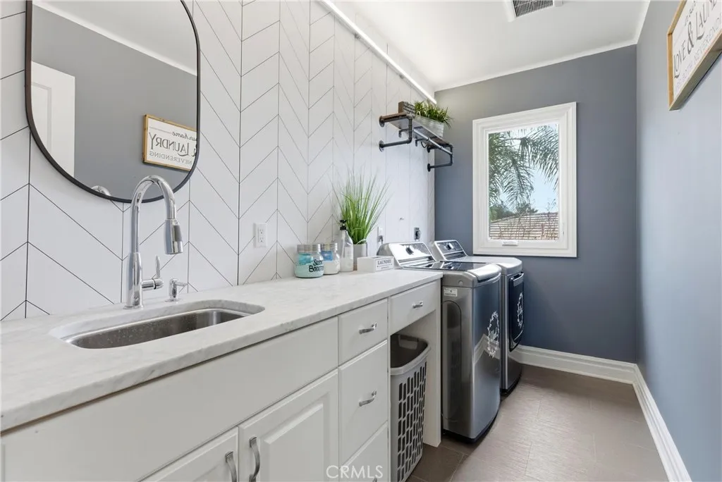 2nd floor laundry room with sink and storage