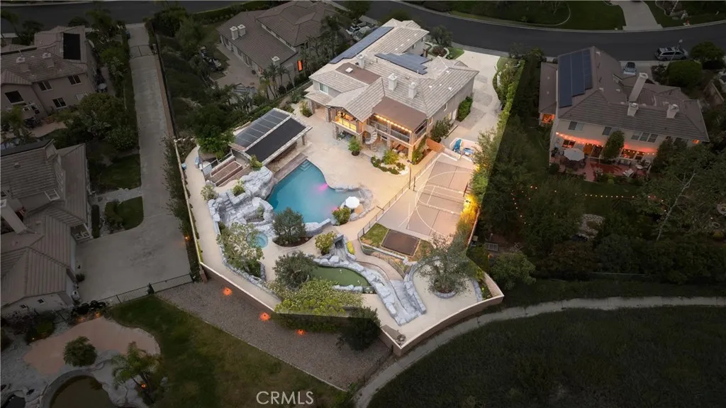 Aerial backyard view showing pool, outdoor kitchen and sports court