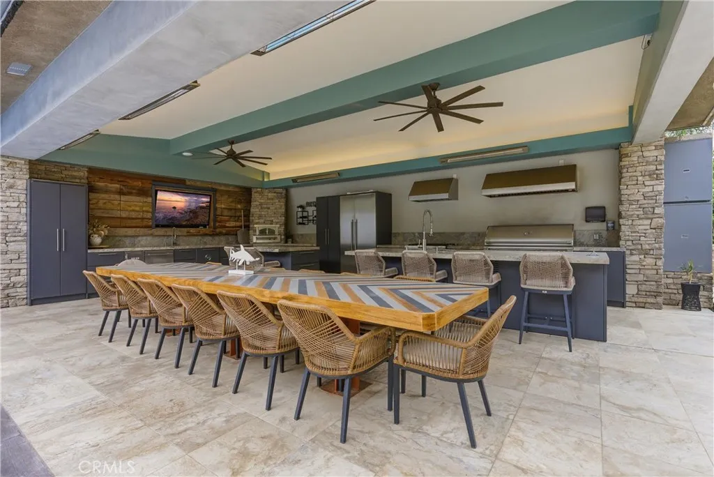 Outdoor kitchen and covered entertaining patio near pool