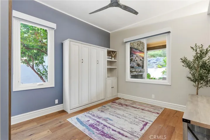 Guest bedroom with Murphy bed and wood flooring