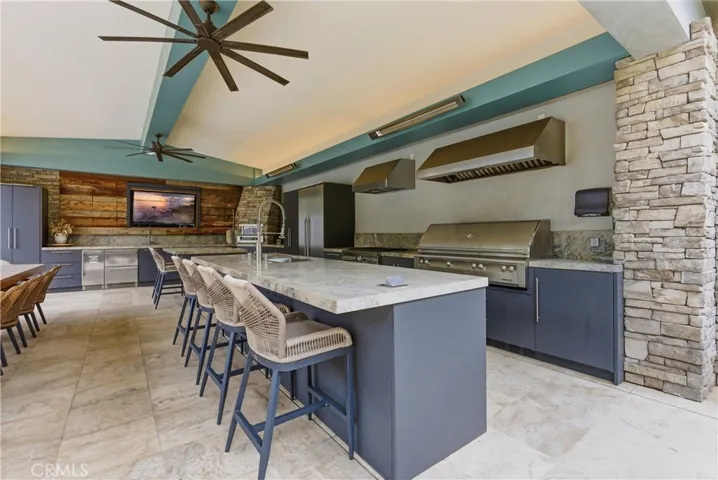 Outdoor kitchen with built-in BBQ, pizza oven and dining area