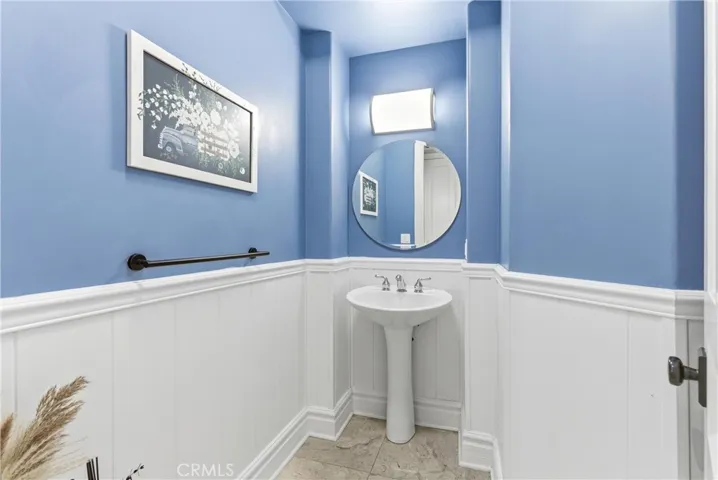 Powder room with pedestal sink and wainscoting