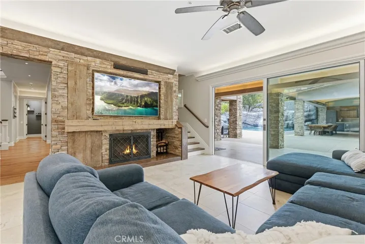 Open concept family room with large feature fireplace and backyard views. Staircase access to west wing for multi generation living