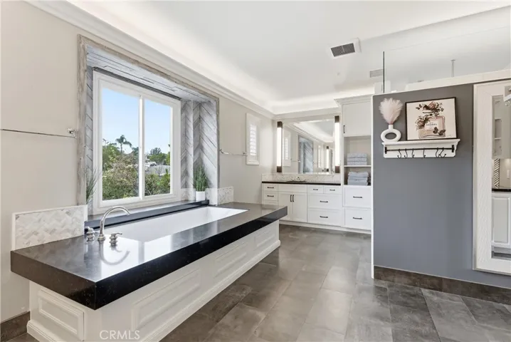 large primary suitr with dual seperate vanaties, large soaker tub, walk in shower, and vanity area.