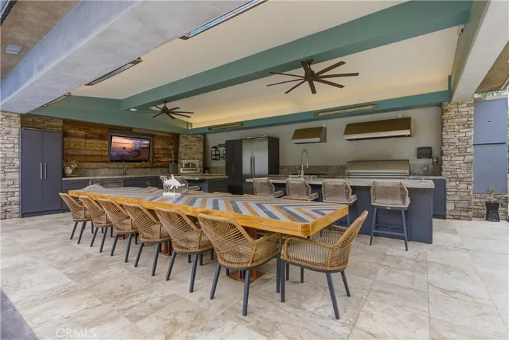 Outdoor kitchen and covered entertaining patio near pool