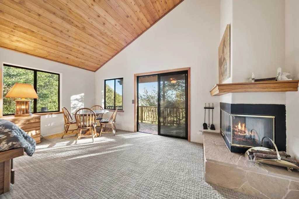 Primary Bedroom with cozy fireplace, private deck and en suite bathroom with walk-in closet.