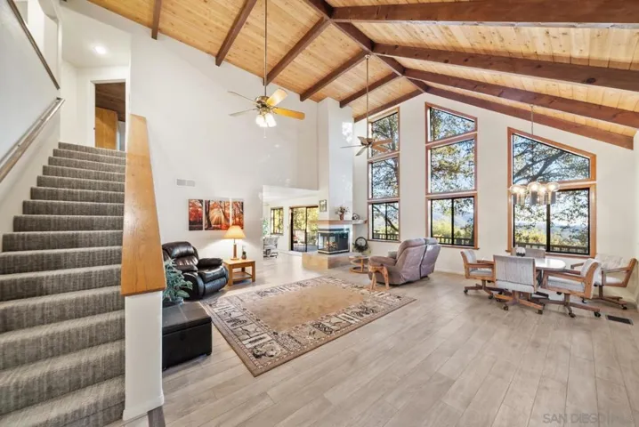 Large living room with tall wood beamed ceilings and cozy fireplace