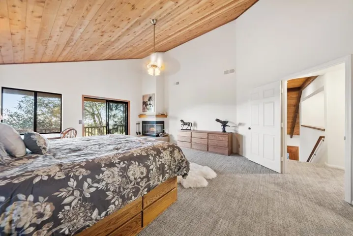 Primary Bedroom with cozy fireplace, private deck and en suite bathroom with walk-in closet.