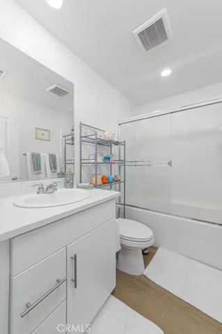 Upstairs full bathroom with tub-shower combo and glass enclosure.