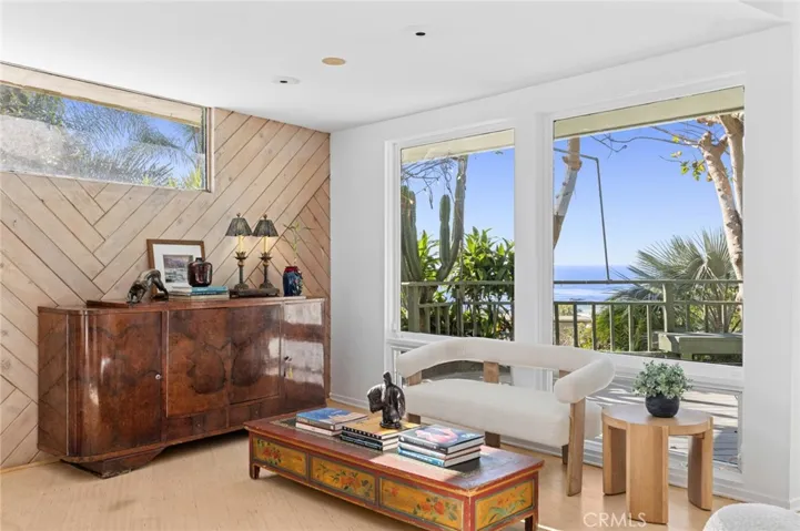 The main living room serves as the showpiece of the home, wrapped in glass to frame sweeping ocean vistas and opening to expansive decks—an inviting backdrop for entertaining or quiet moments alike.