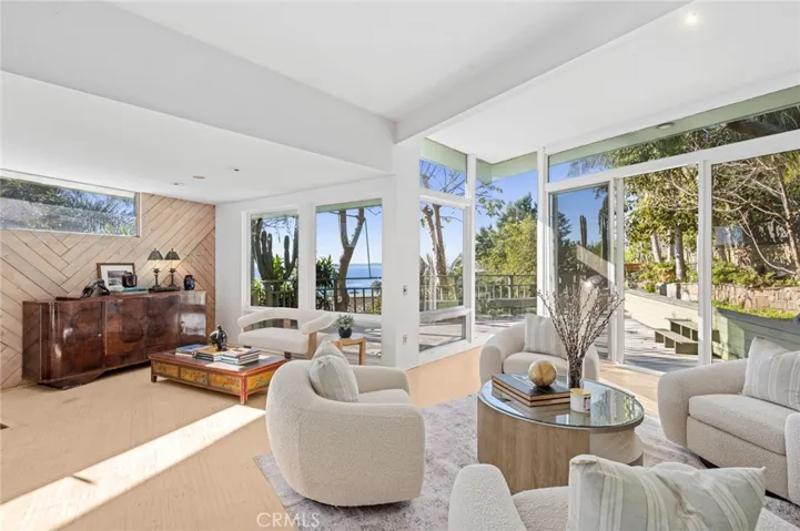 High ceilings, abundant natural light, and an open floor plan define the interior, flowing seamlessly to multiple outdoor decks and private patios.