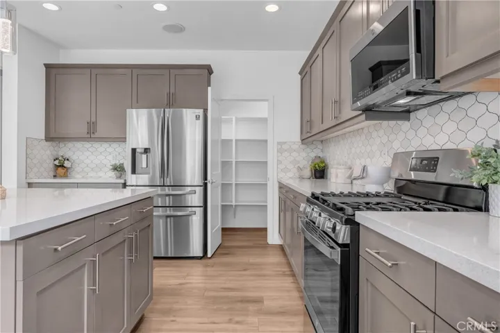 This is your gorgeous kitchen with upgraded stainless steel appliances, designer backsplash, new stove top, and huge walk in pantry