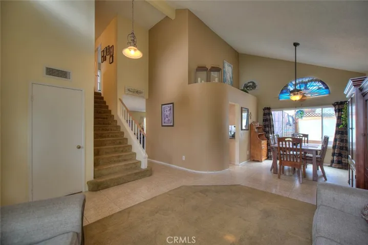 Living room facing upstairs to bedroom, family room entry, dining room, and kitchen entry