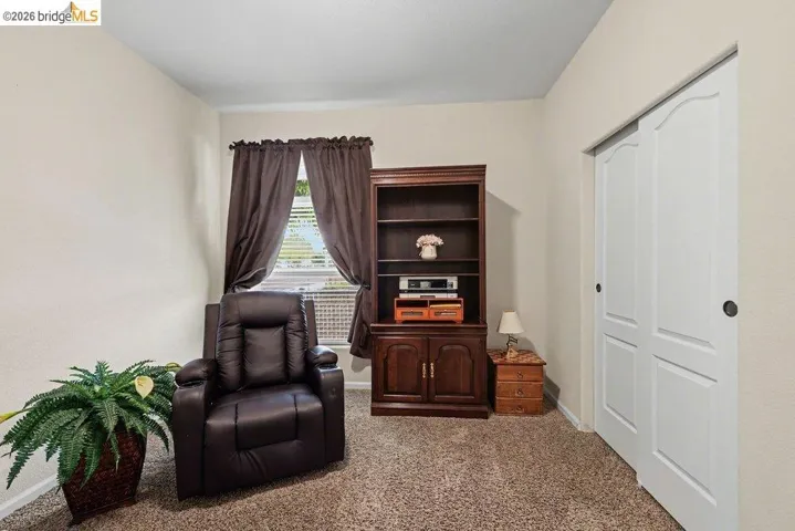Sitting room featuring carpet flooring and baseboards