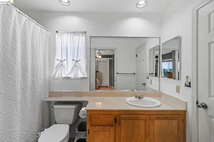 Full bathroom featuring vanity, plenty of natural light, a shower with shower curtain, and a ceiling fan