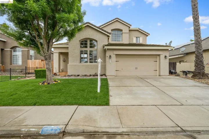 Traditional-style home with stucco siding and concrete driveway