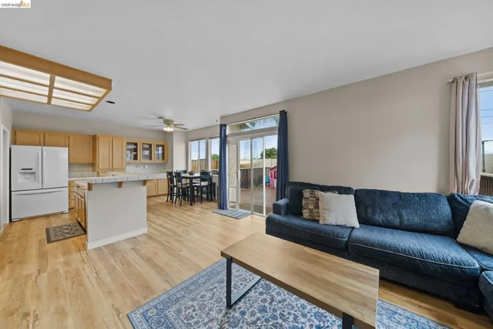 Living room with ceiling fan and light wood-type flooring