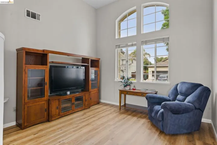 Sitting room with light wood-style flooring and a high ceiling