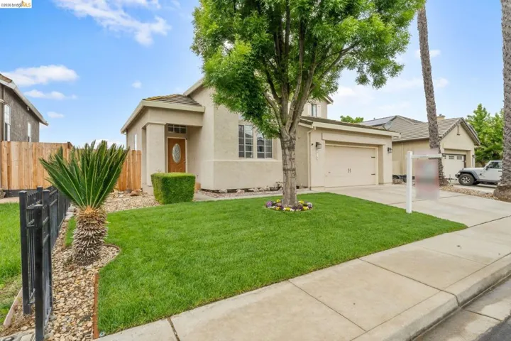 View of front of house featuring stucco siding, concrete driveway, and a garage