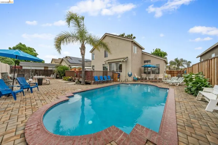 View of swimming pool with patio surround, a fenced backyard, and outdoor dining space