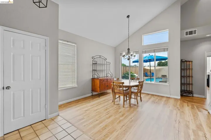 Dining area with lofted ceiling, suspended lighting, and light wood finished floors