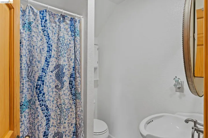 Bathroom featuring a stall shower and a textured wall