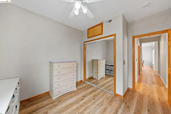 Unfurnished bedroom with a closet, light wood-type flooring, and a ceiling fan
