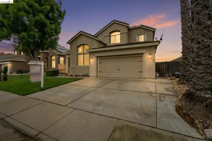 Traditional-style house featuring concrete driveway and stucco siding