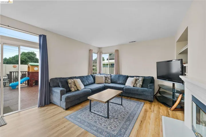 Living room featuring light wood finished floors and a fireplace with flush hearth