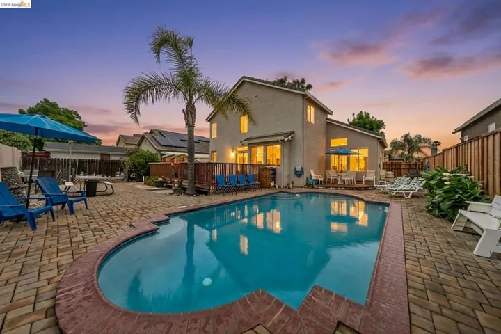 Pool at dusk featuring a patio and a fenced backyard