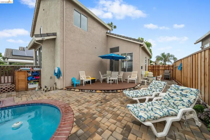 Rear view of house featuring a patio, a fenced backyard, stucco siding, a deck, and outdoor dining area