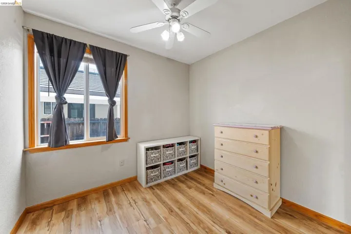 Bedroom with a ceiling fan and light wood-style flooring