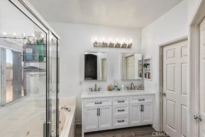 Primary bath with new cabinetry, hardware and lighting.  Dual basins.