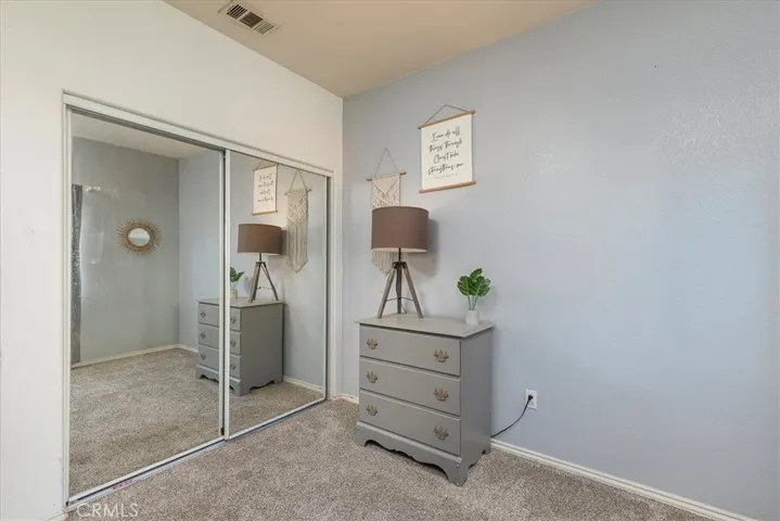 Bedroom with mirrored closet doors.  Fairly new carpet.