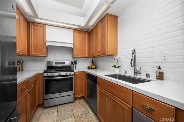 Subway Tile backsplash compliments the quartz countertops and wood cabinetry.