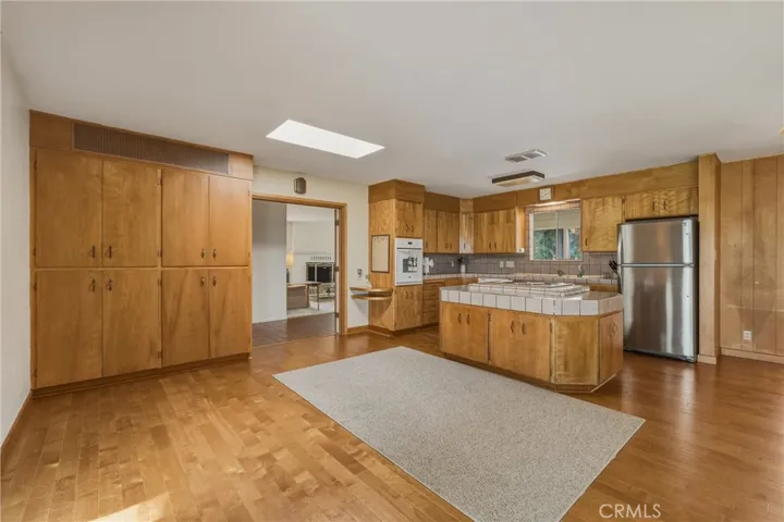 Beautiful hardwood floors with matching cabinets. Kitchen island with stainless steel appliances.