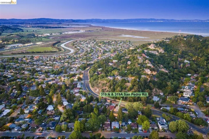 aerial view of property's location featuring nearby suburban area and a water and mountain view