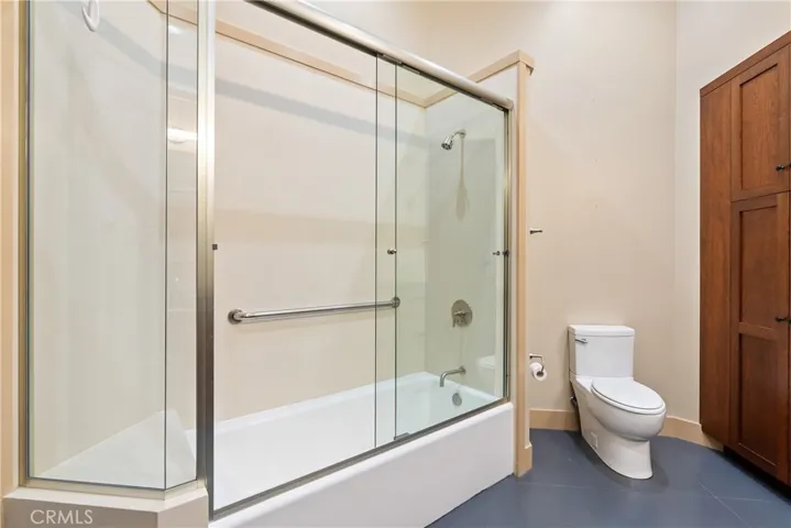 Main bathroom features a large shower/bathtub combination with a hard surface surround.