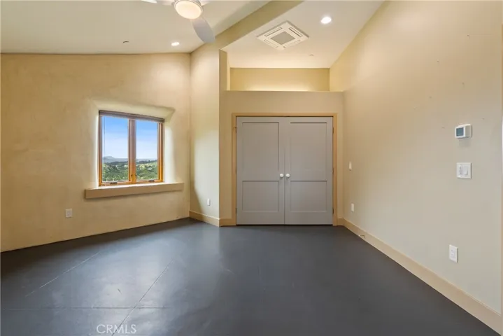 The spacious primary bedroom has a large, reach-in closet and ensuite half-bath. Further, decorative niche, accent wall, and ceiling fan round out this lovely room's design.