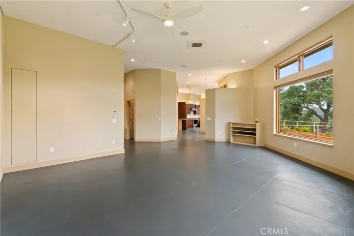 Concrete flooring and built-in entertainment console accent this living space. Do you need shelving? There is hidden storage available. Simply push the hidden door.
