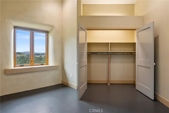 Closet space with lighting, shelving and modern wardrobe rod.