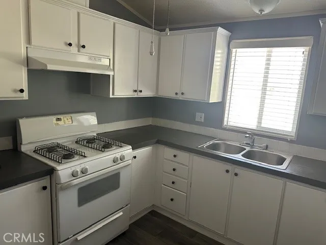 Left hand side of the kitchen.