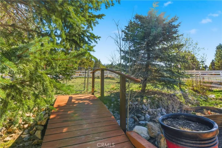 Backyard, walking bridge with rocks, greenery and trees