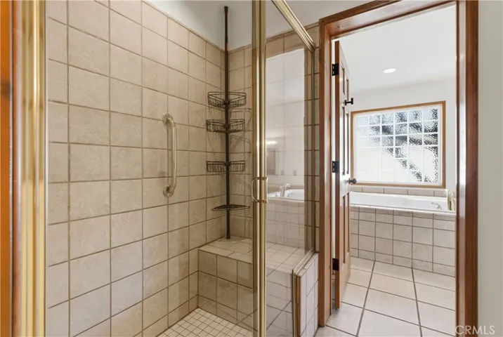 Separate tiled walk in shower with seated area.