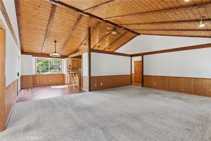 Spacious Living Room with decorative wainscoting and wood beamed ceiling