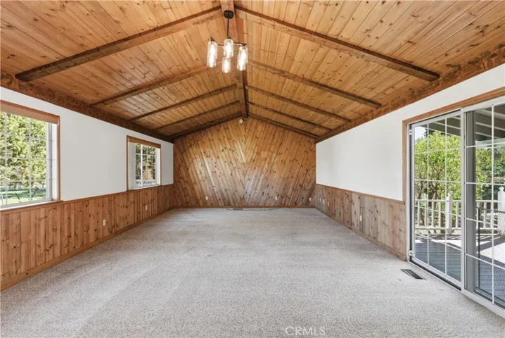 Huge game room, family room, or 4th bedroom option with vaulted ceilings, beautiful wood beams that opens to lovely deck.