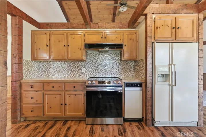 Kitchen with decorative backsplash tile, stove, trash compactor, and fridge. Appliances included!